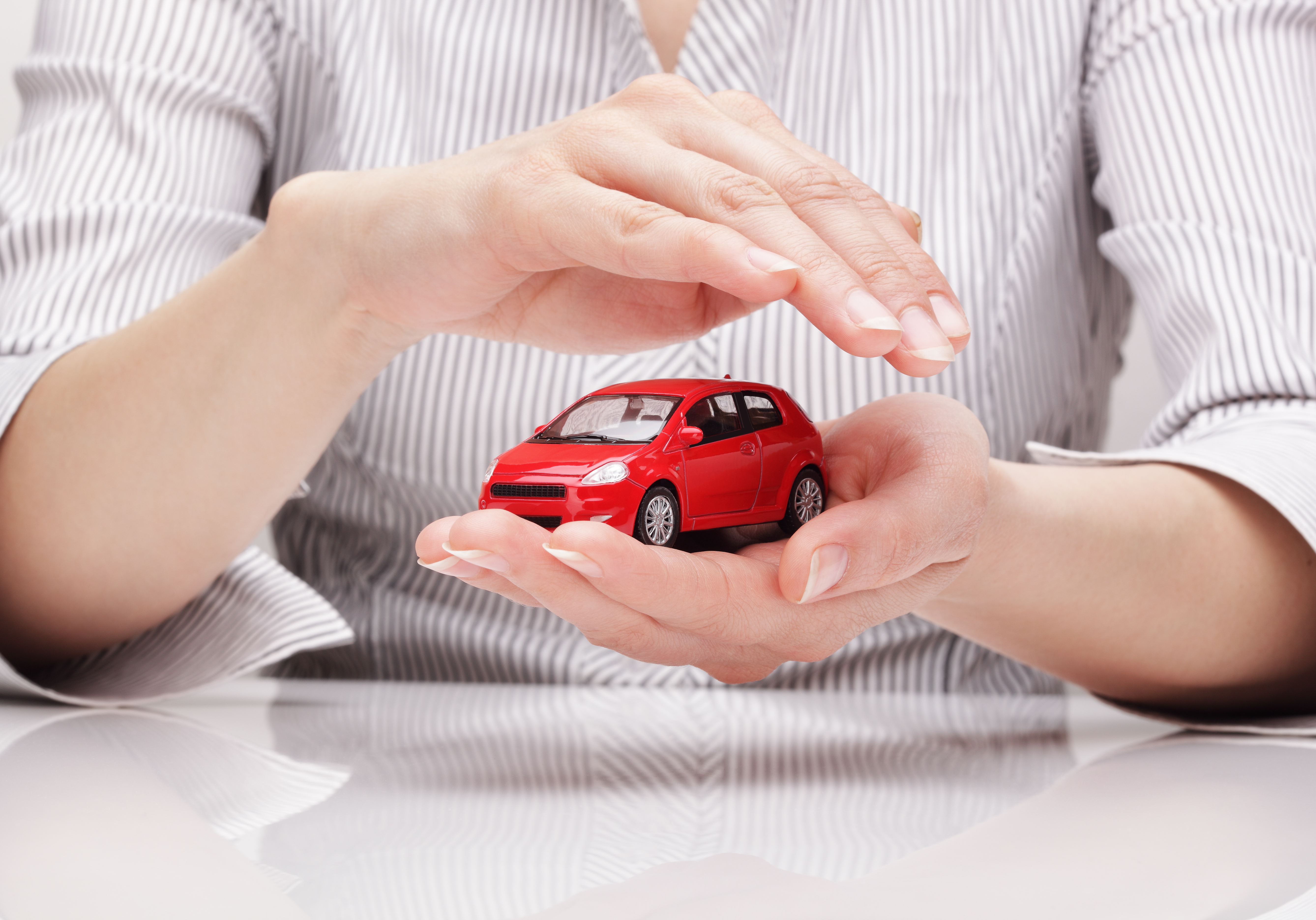 woman with hands covering car
